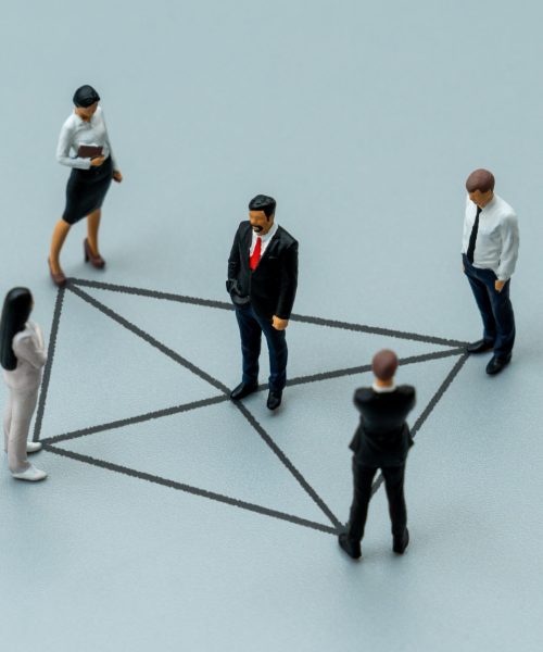 Miniature business figures are connected by drawn lines. Networking, corporate communication, team hierarchy, exchange of information concept.